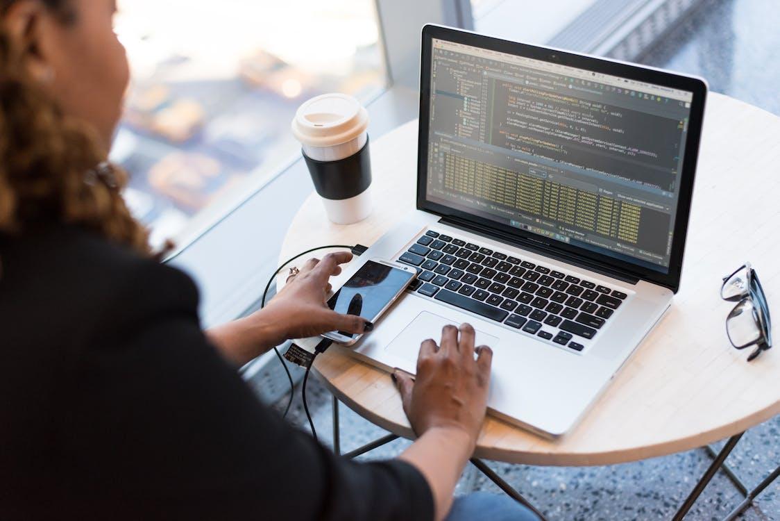 Free Black and Silver Laptop Computer on Round Brown Wooden Table Stock Photo